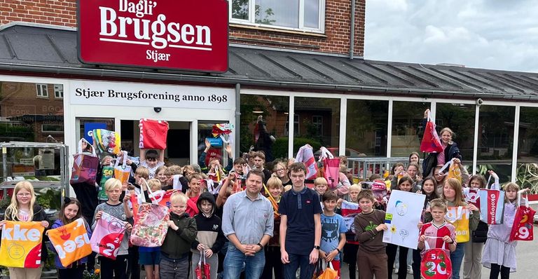 Brugsuddeler Lars sammen med en gruppe skolebørn, der har lavet genbrugsposer