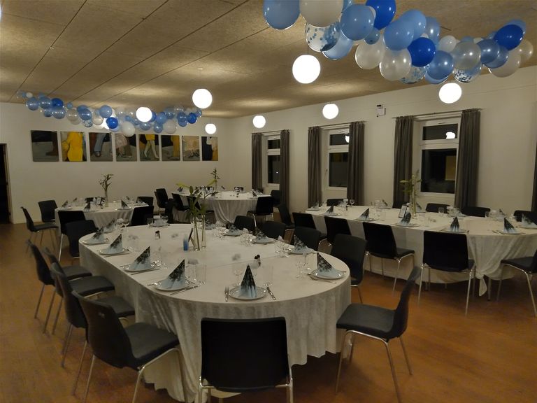 Festsalen dækket op til fest med runde borde